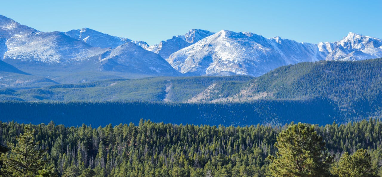 Scenic view of snow-capped mountains and forest in Larimer County, Colorado.